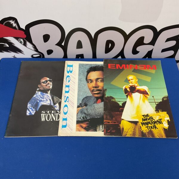 Vintage concert programmes featuring Stevie Wonder, George Benson, and Eminem.