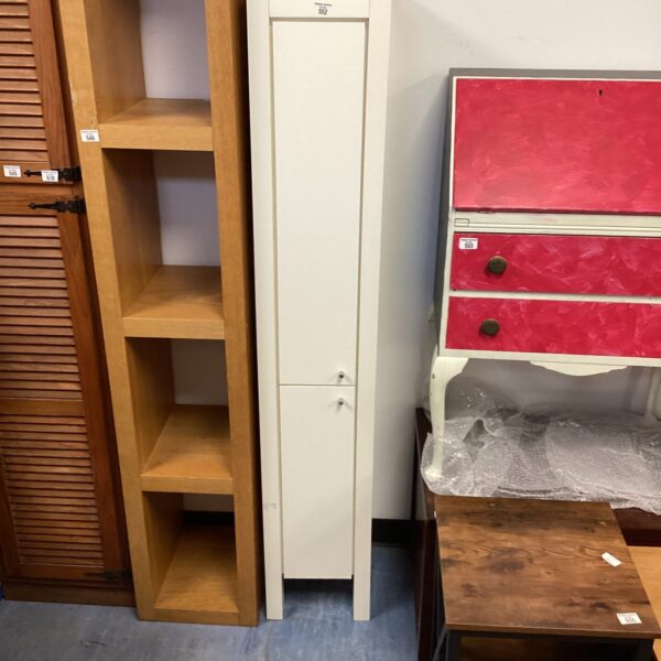 Vintage tall white cupboard with a single door and internal shelving.