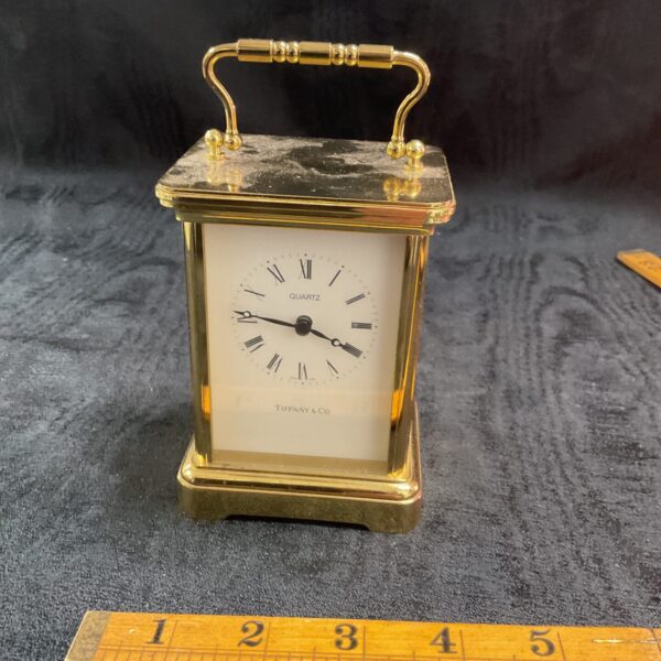 Vintage Tiffany and Co brass quartz carriage clock on display.