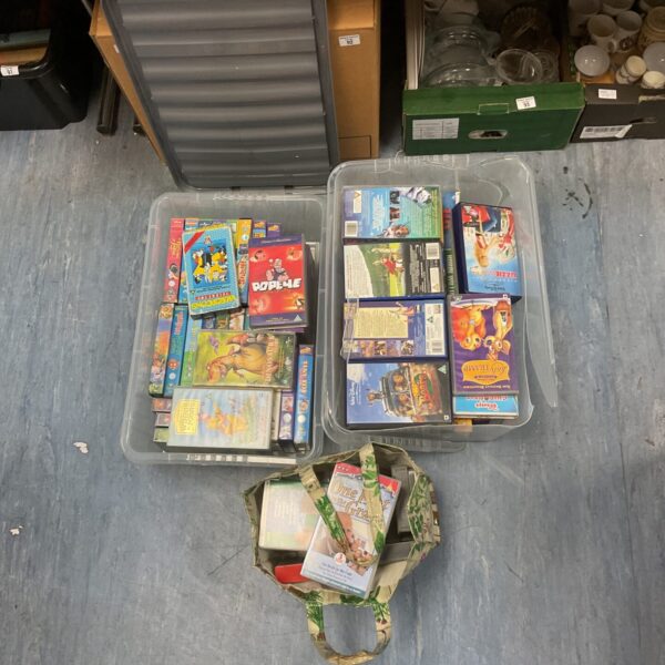 VHS movie lot in storage boxes and a bag.