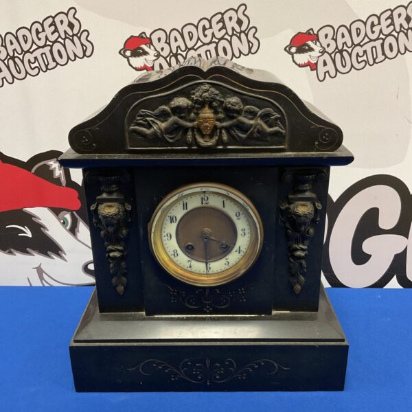 Antique Victorian slate mantle clock with cherub details.