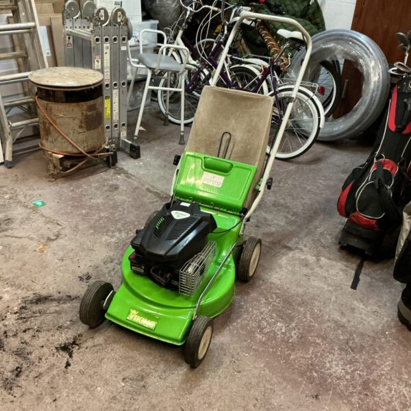 Side view of a used Viking petrol lawnmower in a workshop.