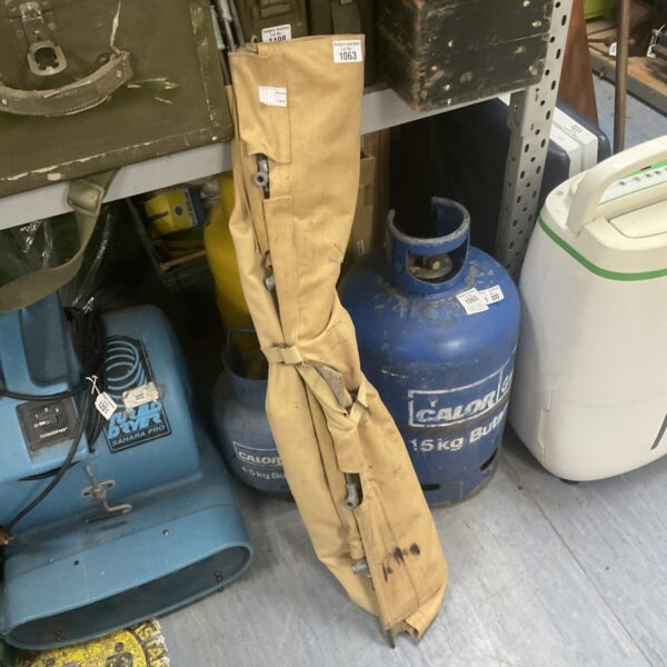 Vintage army camp bed with canvas surface and metal frame.