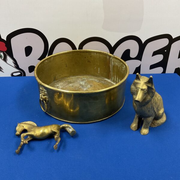 Vintage brass bowl with lion head handles and brass figurines.