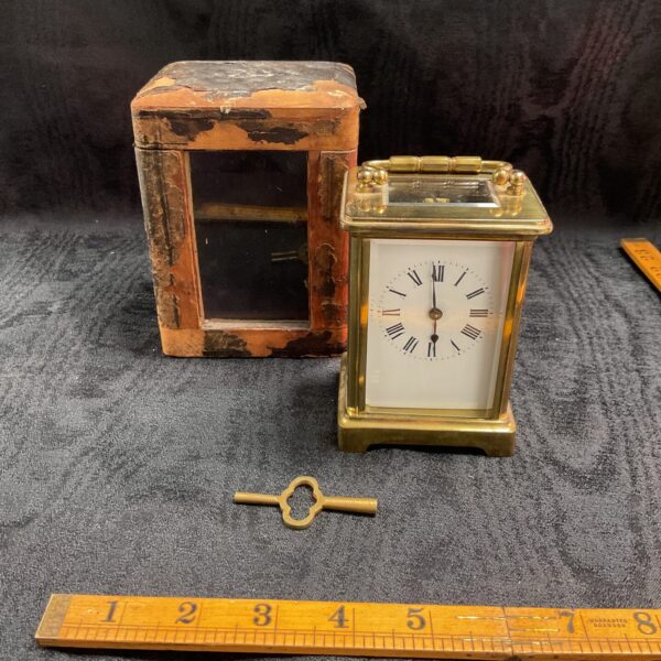Vintage brass carriage clock with travel case and key.