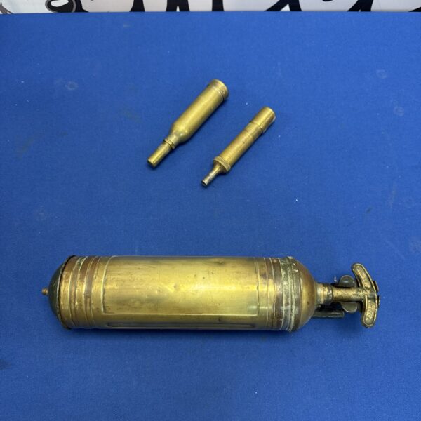 Vintage brass grease gun with nozzle, antique lubrication tool.