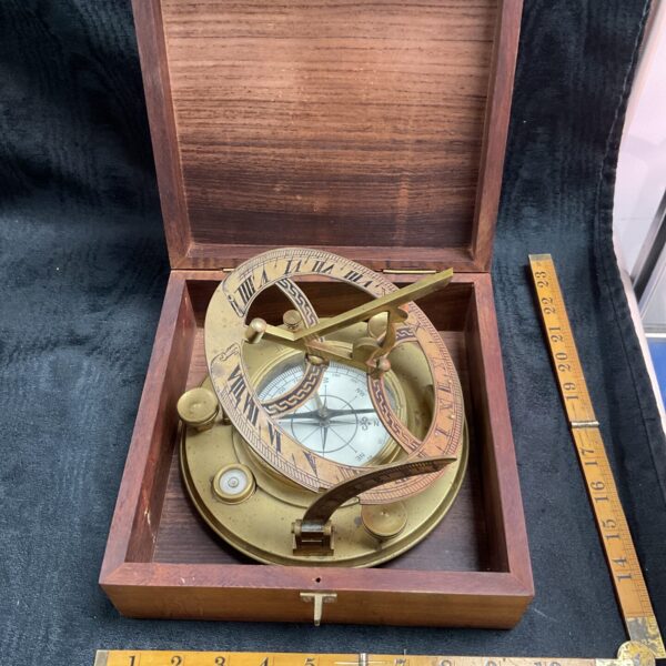 Vintage brass ship compass with degree markings and sighting mechanism.