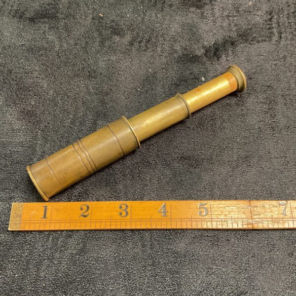 Side view of a vintage brass pocket telescope.