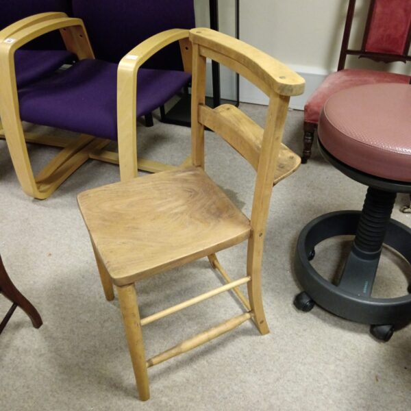 Vintage wooden chapel chair with curved back.