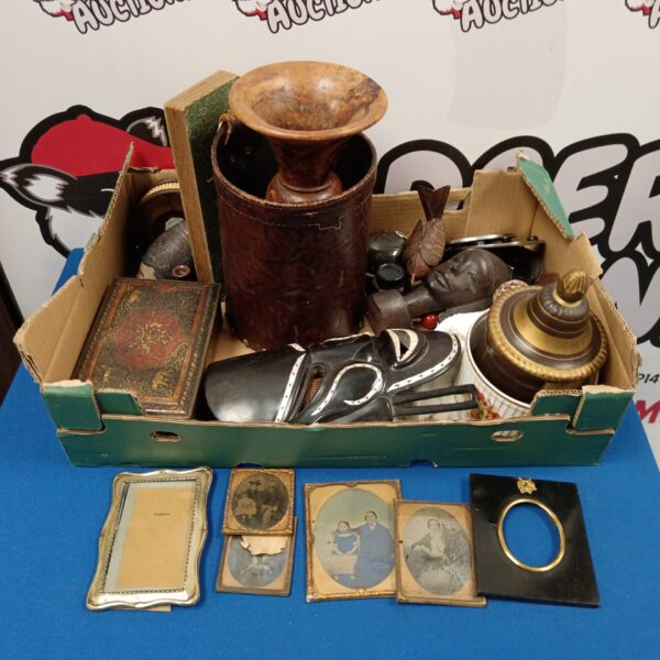 Vintage tray of collectibles including a tribal mask and Victorian frames.