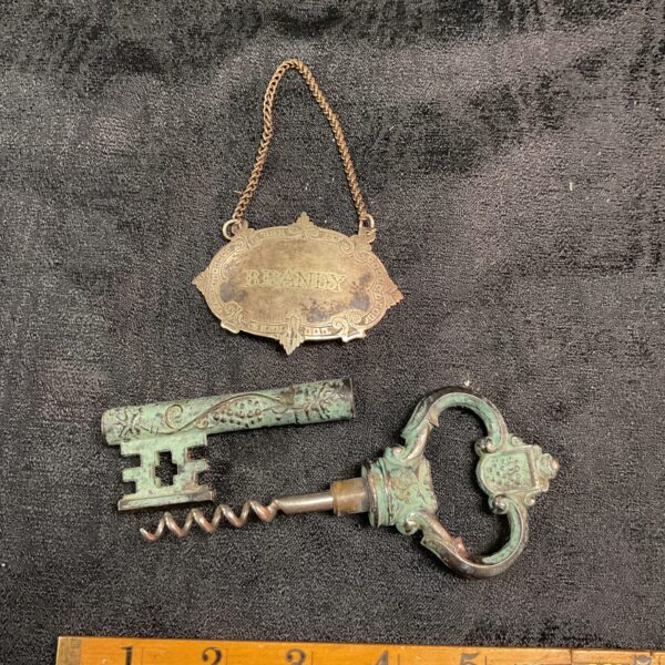 Vintage brass corkscrew and brandy label set, antique barware collectible.