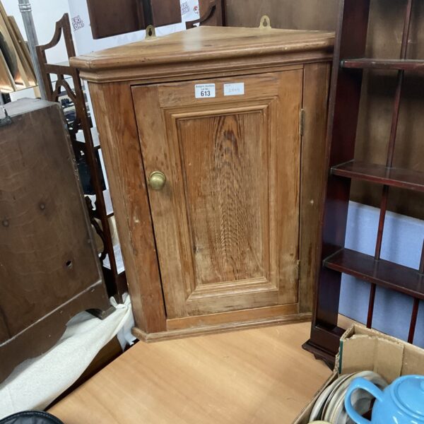 Vintage wooden corner cupboard with a single door, ideal for storage.