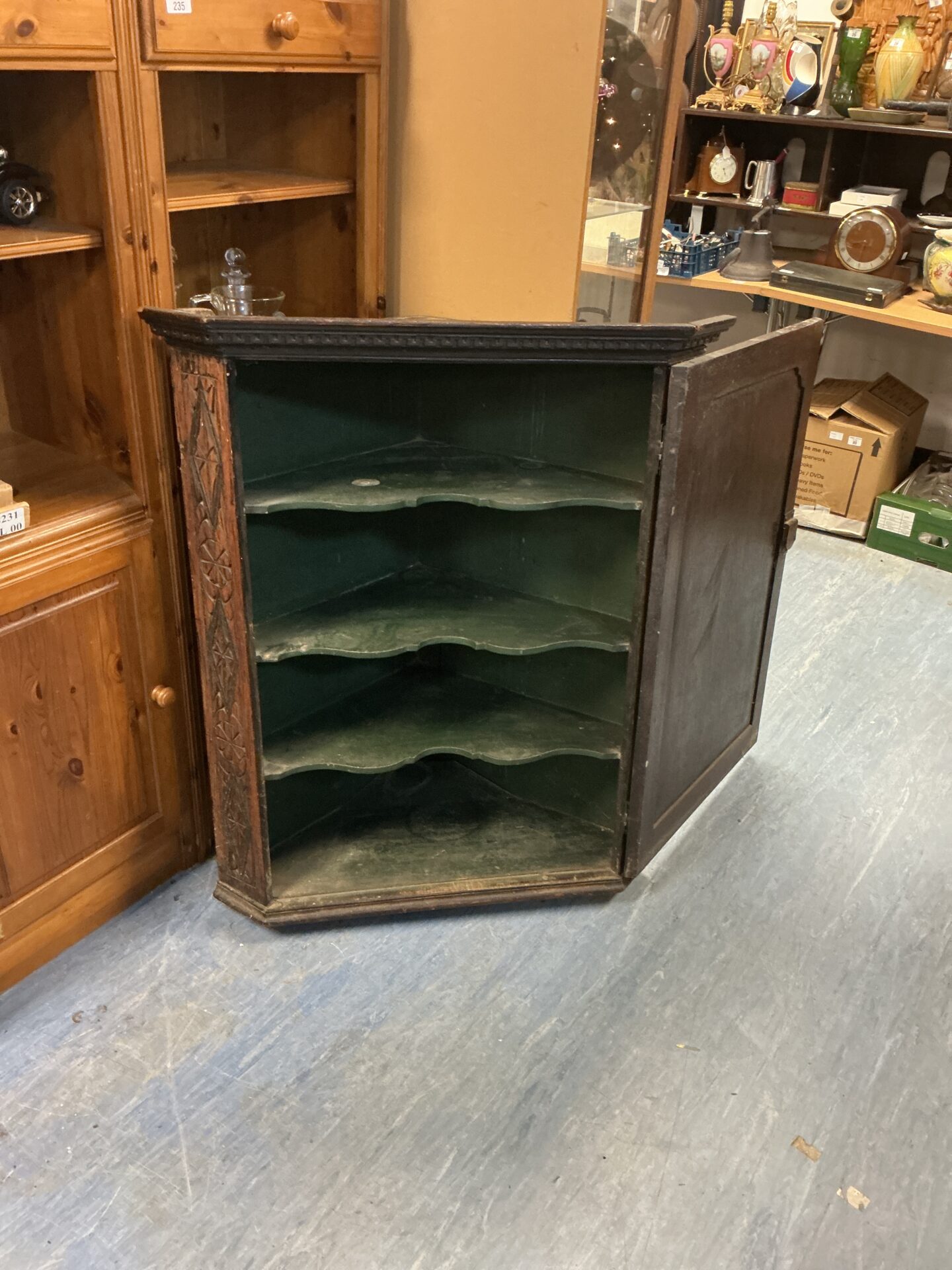 Interior view of a vintage mahogany corner unit with green shelves.