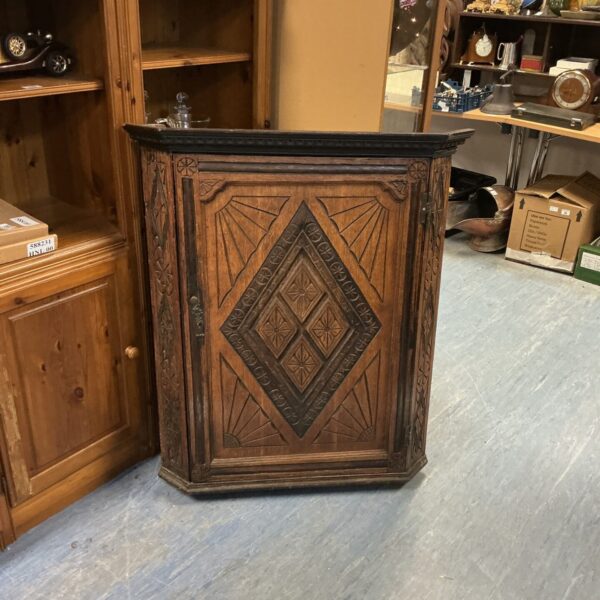 Side view of a vintage mahogany corner unit with carved details.