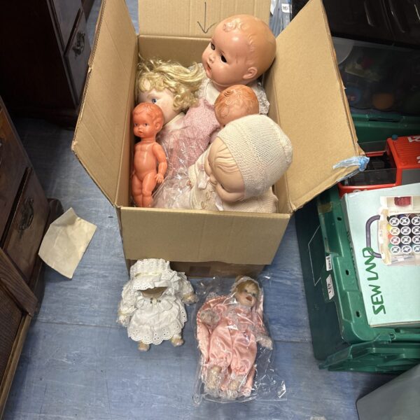 Mixed lot of vintage dolls in a cardboard box.
