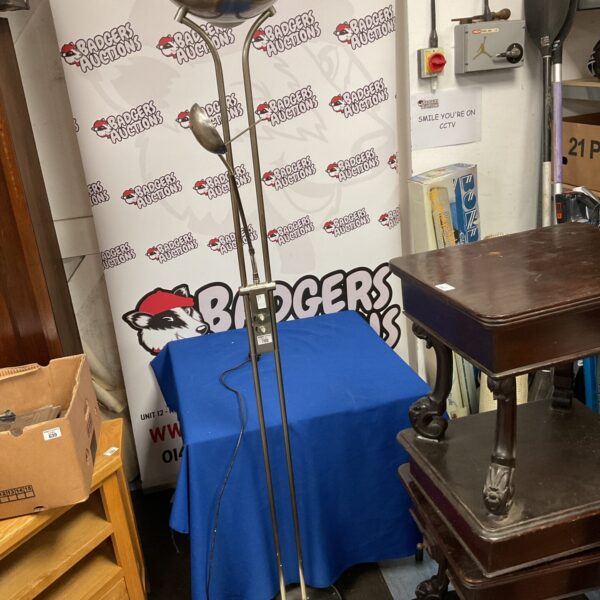 Vintage floor lamp with adjustable reading light in a room setting.
