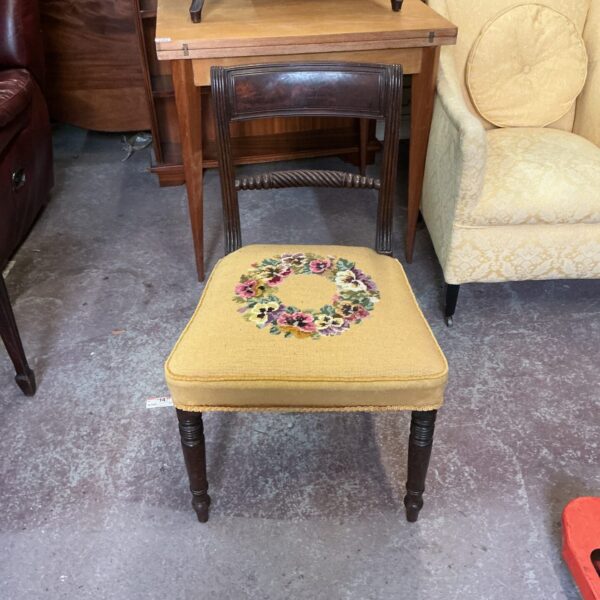 Vintage floral upholstered chair with turned wooden legs.