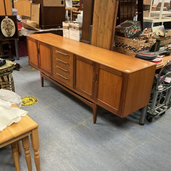 Front view of a vintage G-Plan teak sideboard with drawers and cupboards.