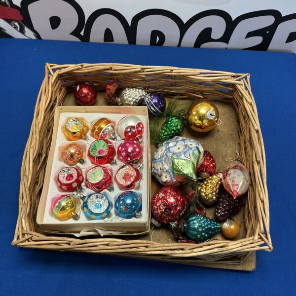 Lot of vintage glass Christmas baubles in a woven basket.