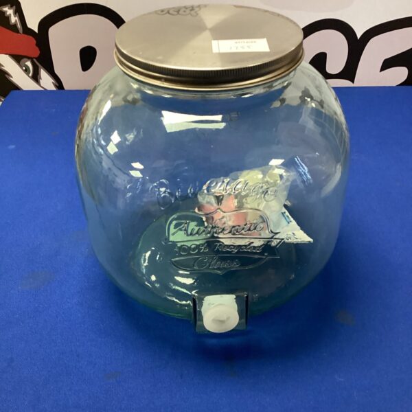 Vintage glass drinks dispenser with tap for serving beverages.