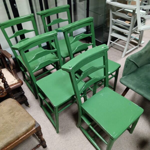 Set of five vintage green chapel chairs with wear.