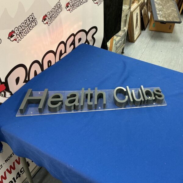 Vintage health clubs sign with raised lettering, retro advertising.
