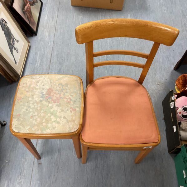 Vintage kitchen stool with patterned seat, rustic farmhouse style.