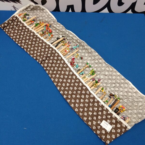 Vintage lace making bobbins arranged in a protective roll.