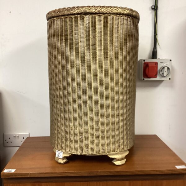 Vintage gold Lloyd Loom wash bin for laundry storage.