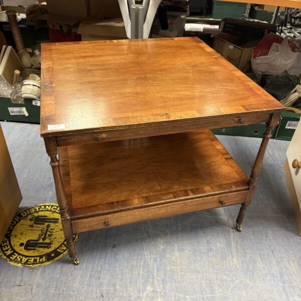 Vintage mahogany coffee table with wheels and lower shelf.