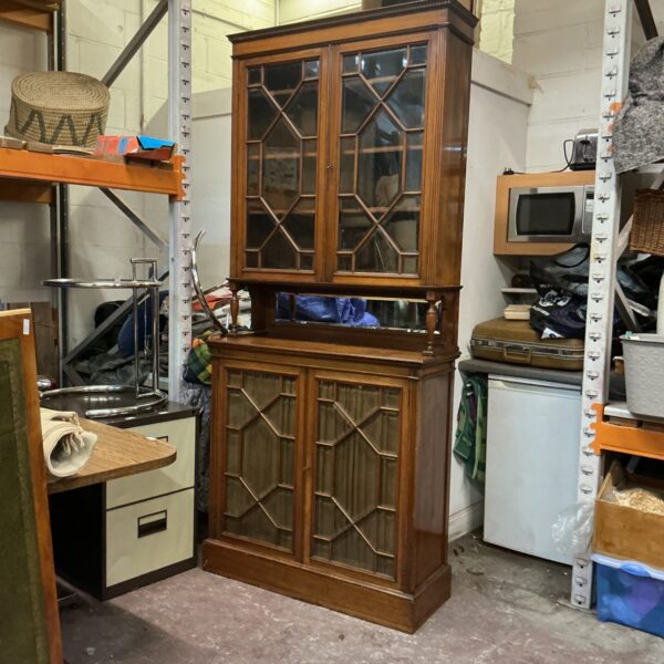 Vintage mahogany display cabinet with glass doors for collectibles.