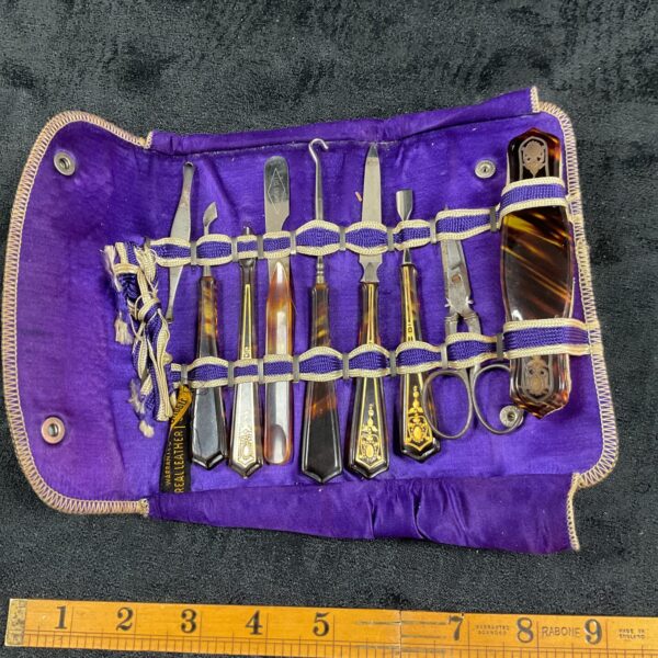 Open vintage manicure set with purple leather case and faux tortoise shell tools.