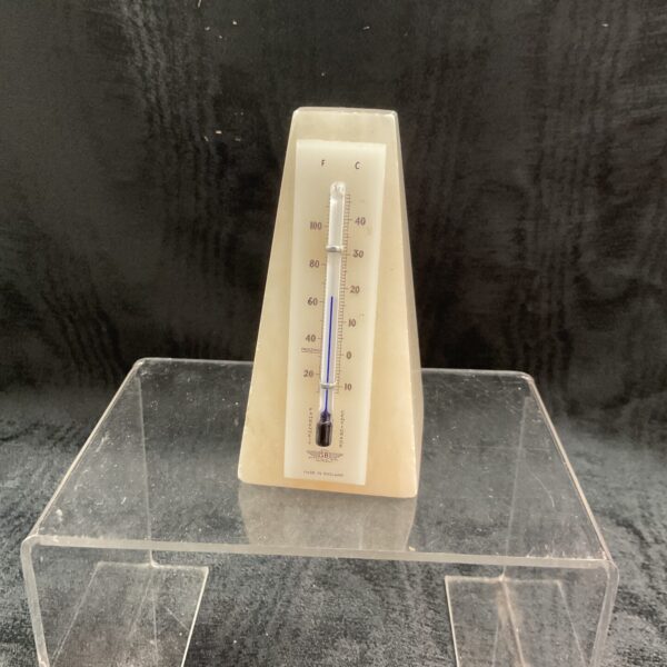 Vintage marble thermometer displaying Fahrenheit and Celsius scales.