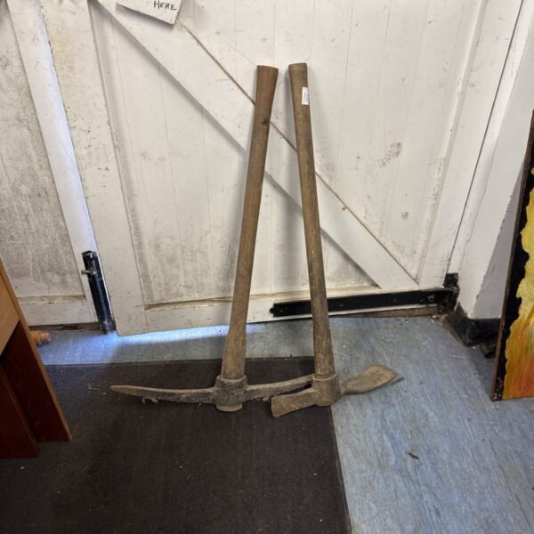 Weathered vintage mattock and pickaxe set, antique garden tools.