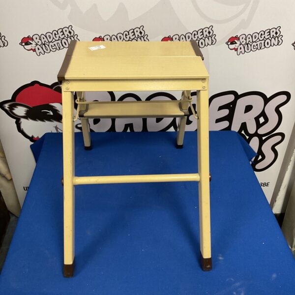 Vintage metal folding step stool for kitchen or storage.