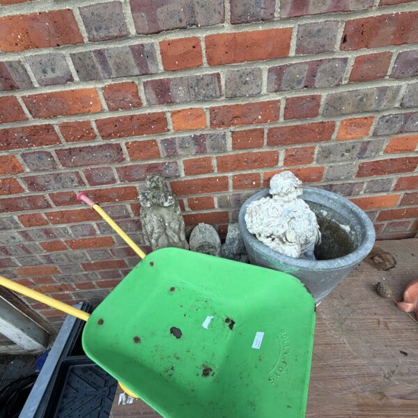 Vintage metal garden wheelbarrow with wooden handle.