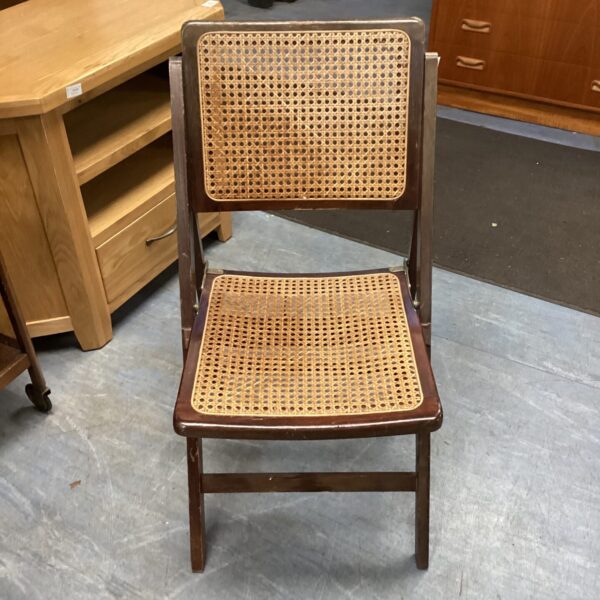 Vintage rattan folding chair with woven seat and dark wood frame.