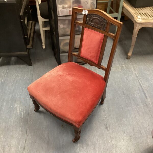 Vintage red upholstered nursing chair with Victorian details.