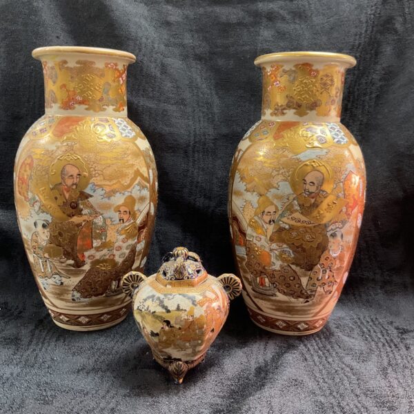 Vintage Japanese Satsuma vases and lidded jar with detailed decoration.