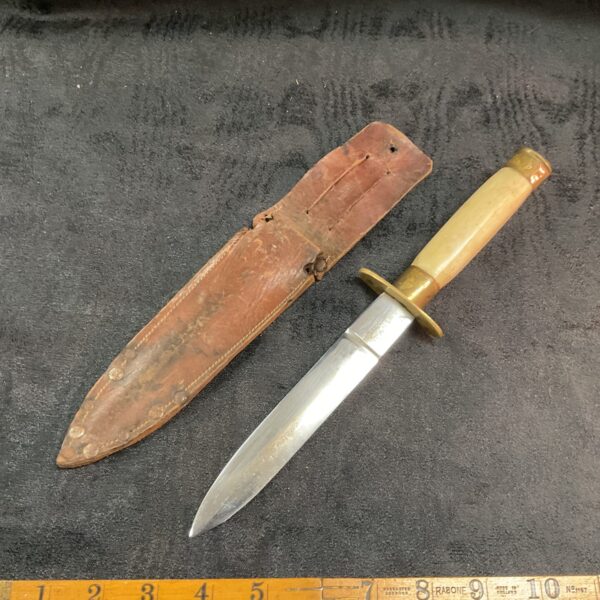 Vintage sheath knife with leather sheath, antique collectible.