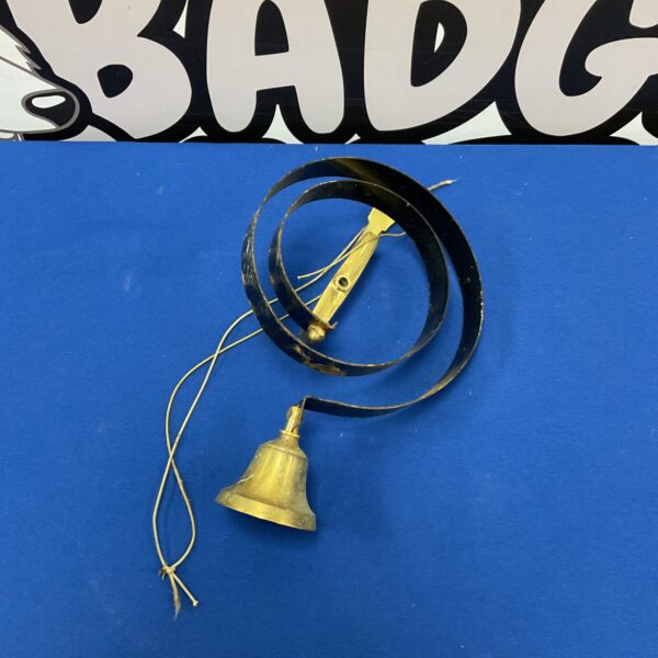 Vintage brass shop door bell with twine suspension.