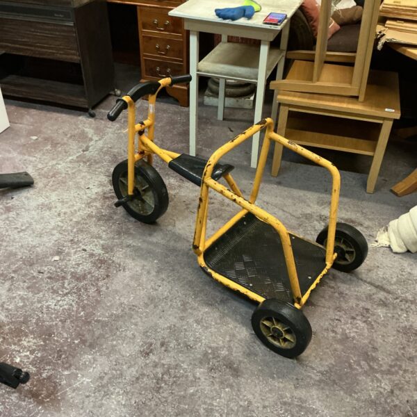 Vintage three wheeled bike with yellow frame and black seat.