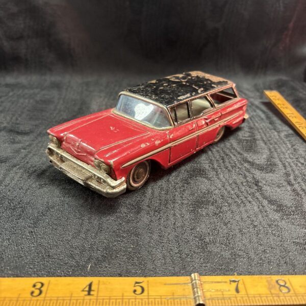 Vintage tinplate Chevrolet station wagon, collectible retro toy car.