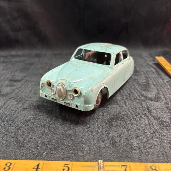 Vintage tinplate Jaguar MK I toy car, collectible retro model.