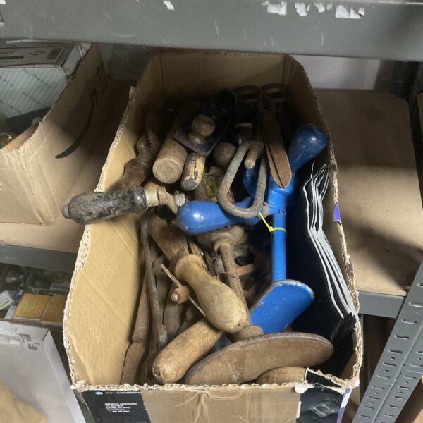 Assorted vintage hand tools in a cardboard box.