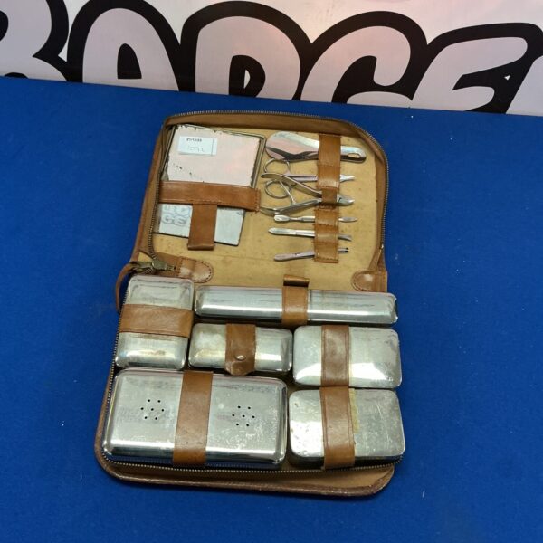 Open vintage gentleman’s travelling kit with silver instruments.