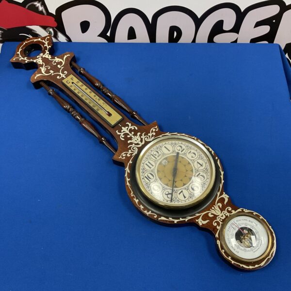 Vintage wall barometer clock with Roman numeral dial and wooden frame.