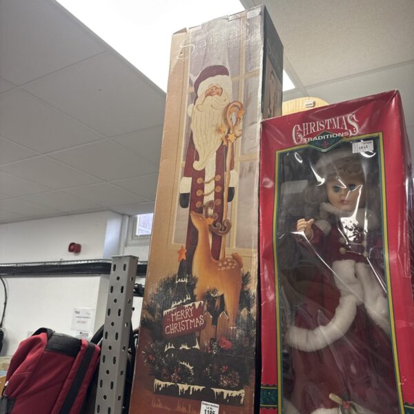 Vintage wooden Santa sculpture with festive Christmas packaging.