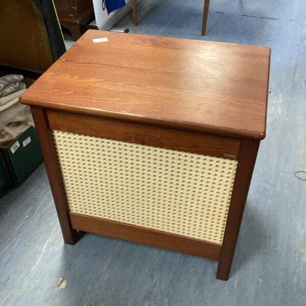 Vintage wooden wash bin with slatted front for laundry storage.