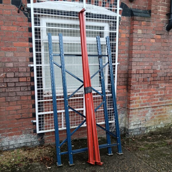 Blue and red metal warehouse racking sections for storage.